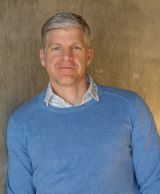 Presenter's photo. Man with blue collared shirt and medium blue sweater.